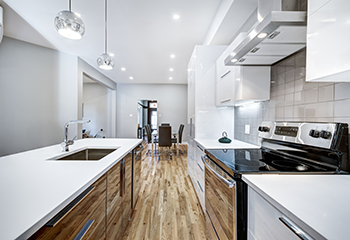 Modern kitchen design featuring white cabinetry, stainless steel appliances, and pendant lighting in Burbank apartment.